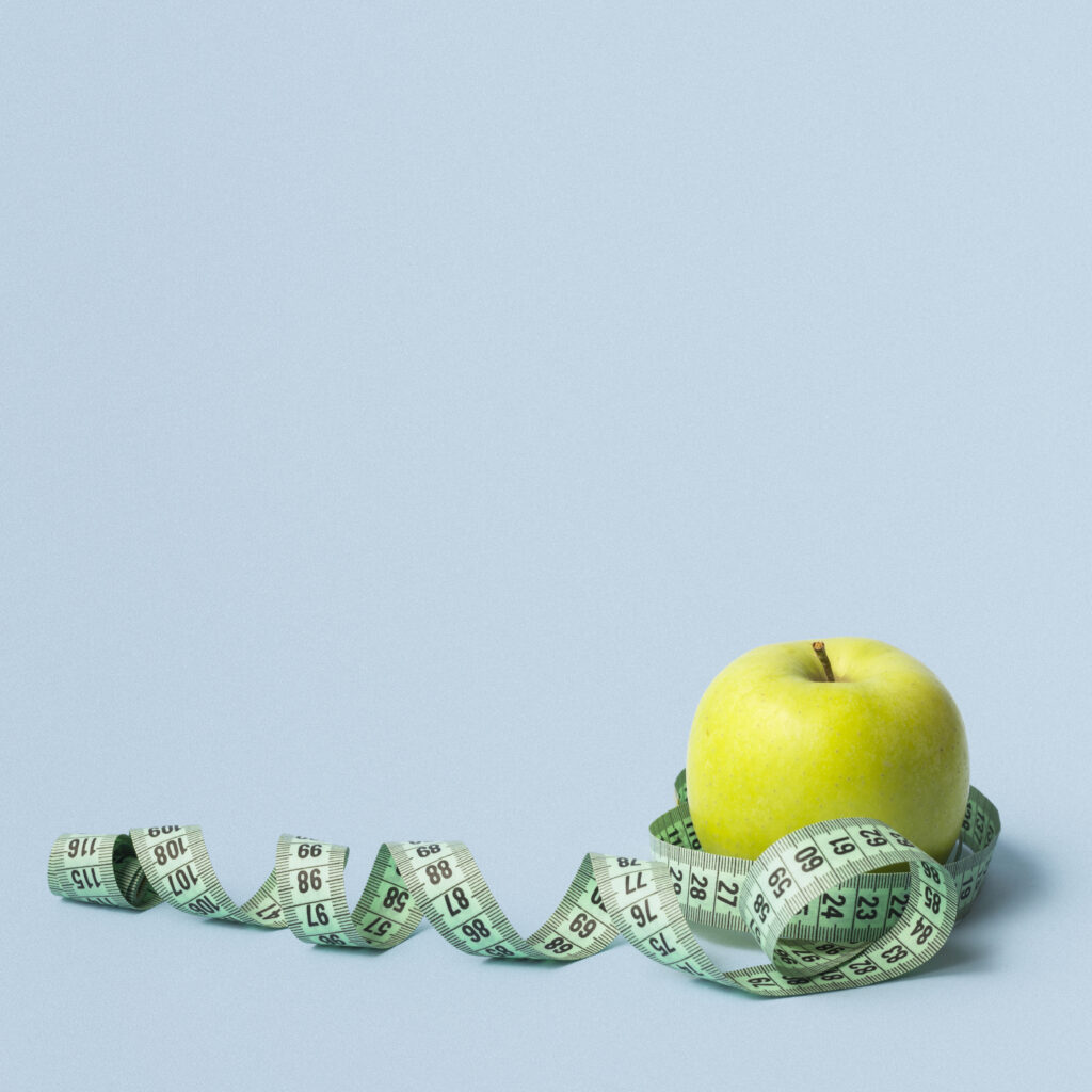 une pomme et un mettre ruban pour garder la ligne